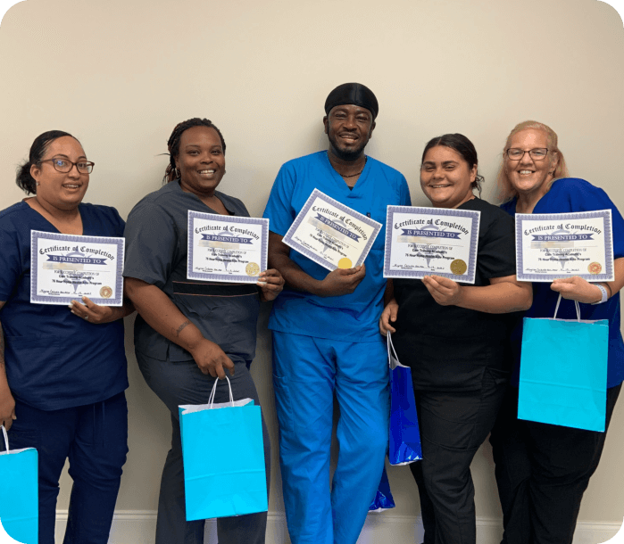 Five medical staffs holding certificates and smiling together