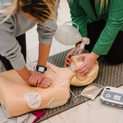 Automated external defibrillator device, AED with training dummy mannequin. Use an automatic defibrillator in conducting basic cardiopulmonary resuscitation of victim. Demonstrating chest compressions