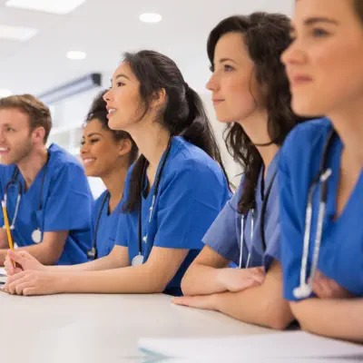 Six medical students smiling together while listening to a discussion