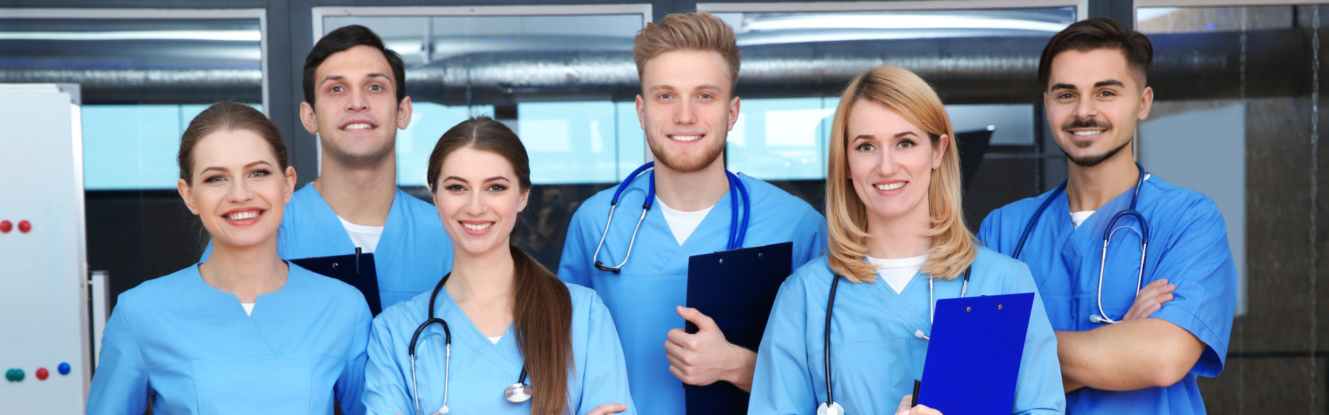 Six medical staffs smiling while the other staffs are holding medical records