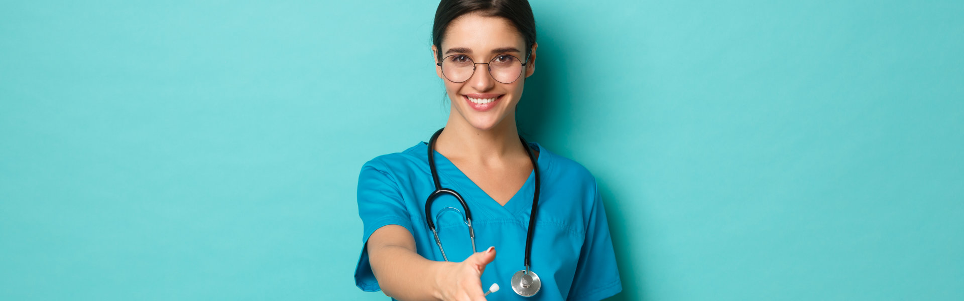 A female nurse doing a handshake pose and smiling