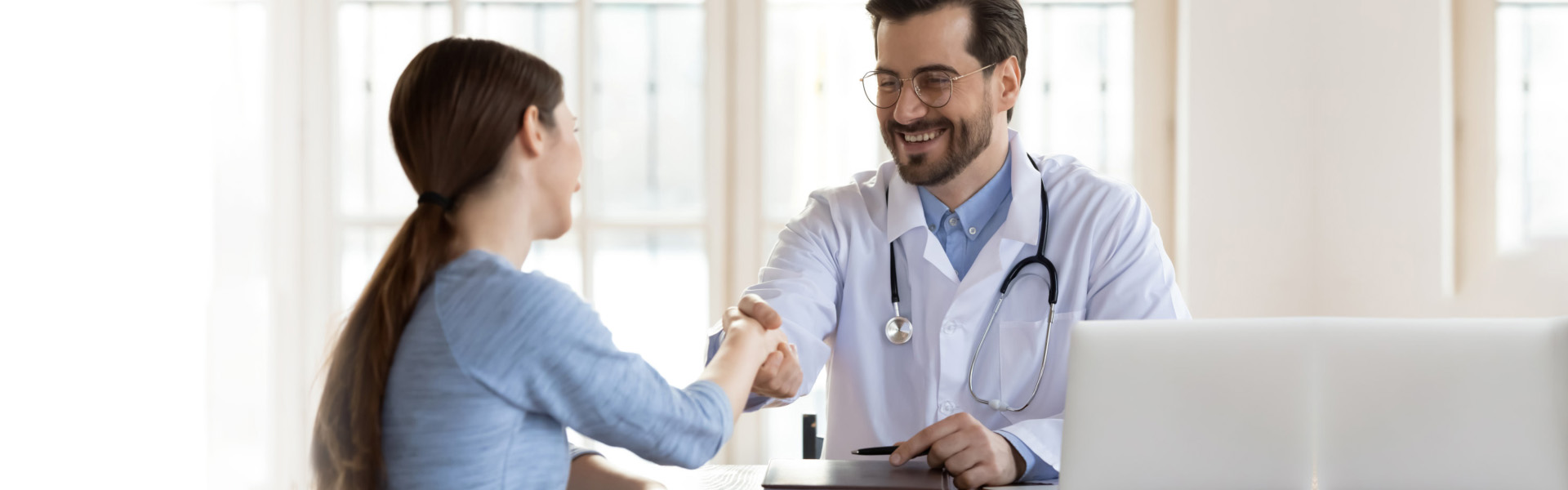 A male doctor shaking the hands of a female