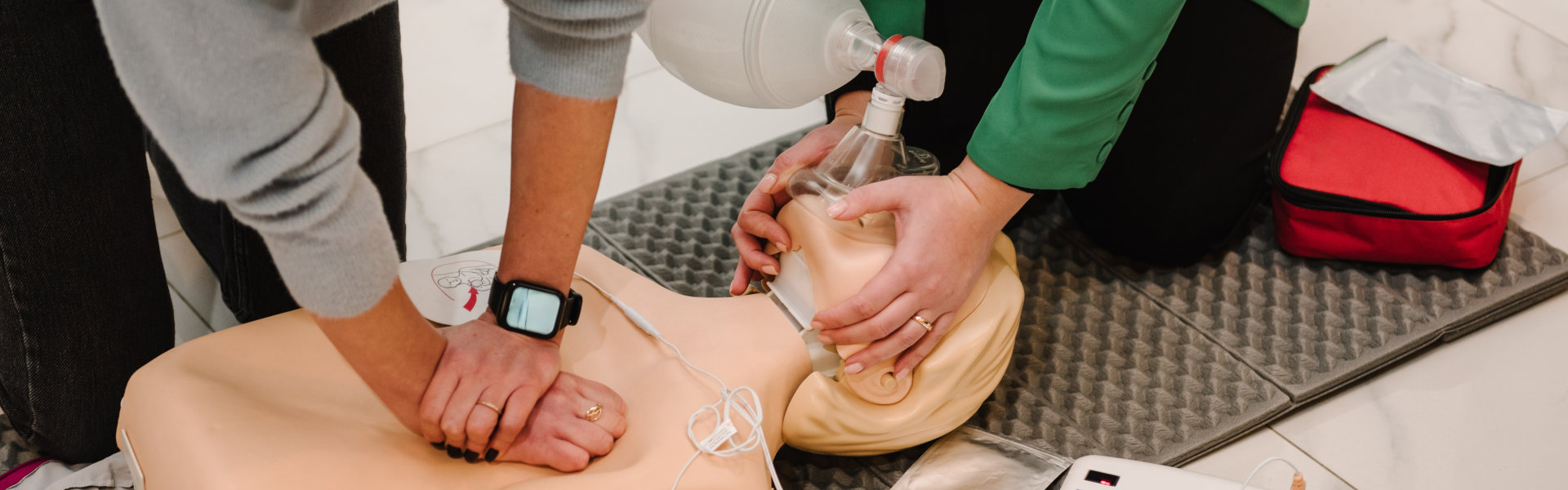 Automated external defibrillator device, AED with training dummy mannequin. Use an automatic defibrillator in conducting basic cardiopulmonary resuscitation of victim. Demonstrating chest compressions